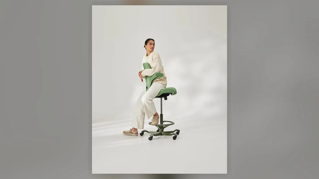 Person working at elevated height on a HÅG Capisco saddle chair, showing the gas lift column and base