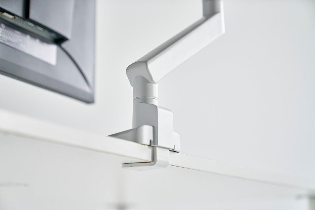 Premium monitor arm mounted on oak desk with dark charcoal background - Chair Dinkum
