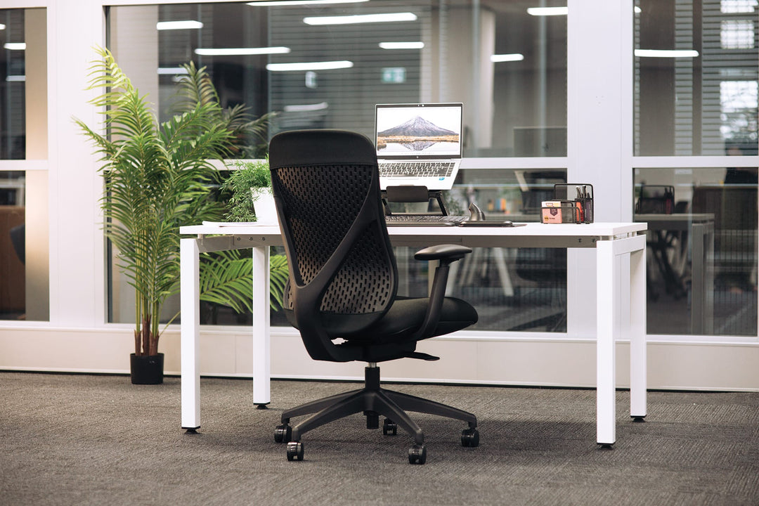 Buro Axon office chair in black with arms at a white desk in an office