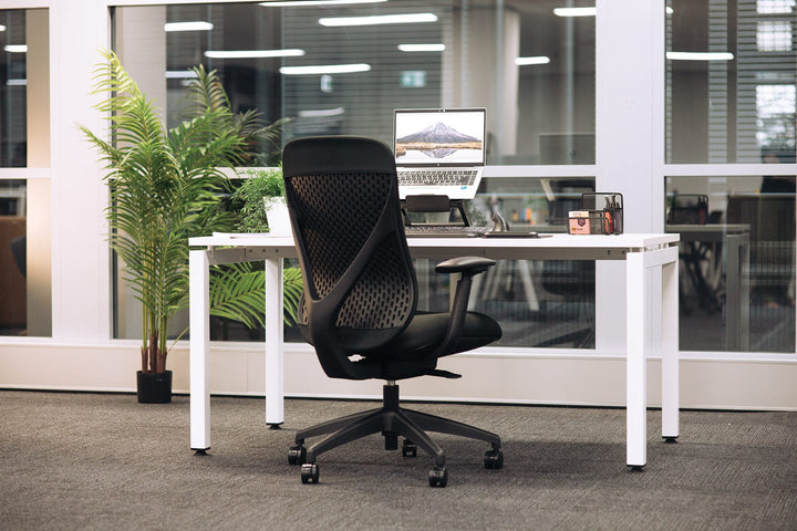 Buro Axon office chair in black with arms at a white desk in an office