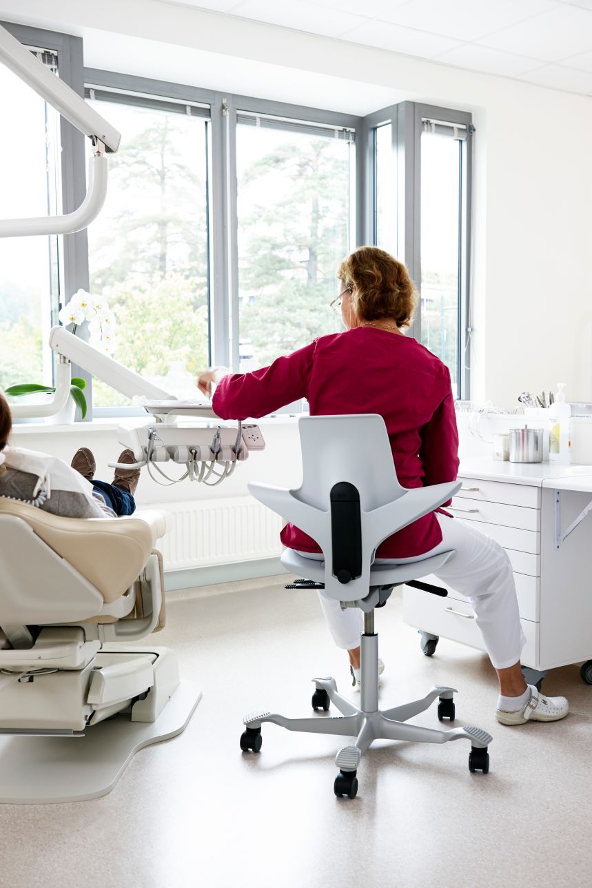 Close up of dentist working from Capisco chair