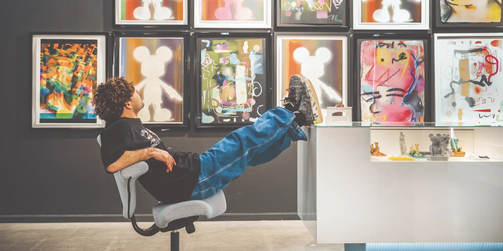 Person leaning back on HAG Capisco chair with feet up in art gallery - Chair Dinkum Australia