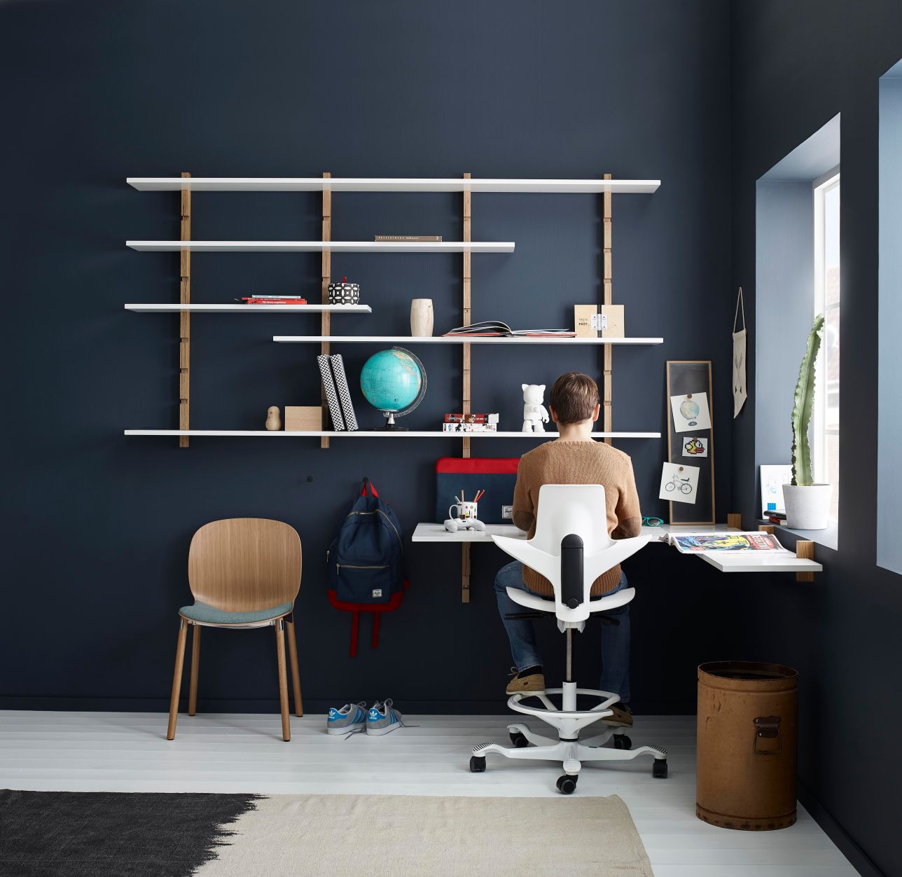 Young person using HAG Capisco Puls 8020 at study desk with shelving - Chair Dinkum Australia