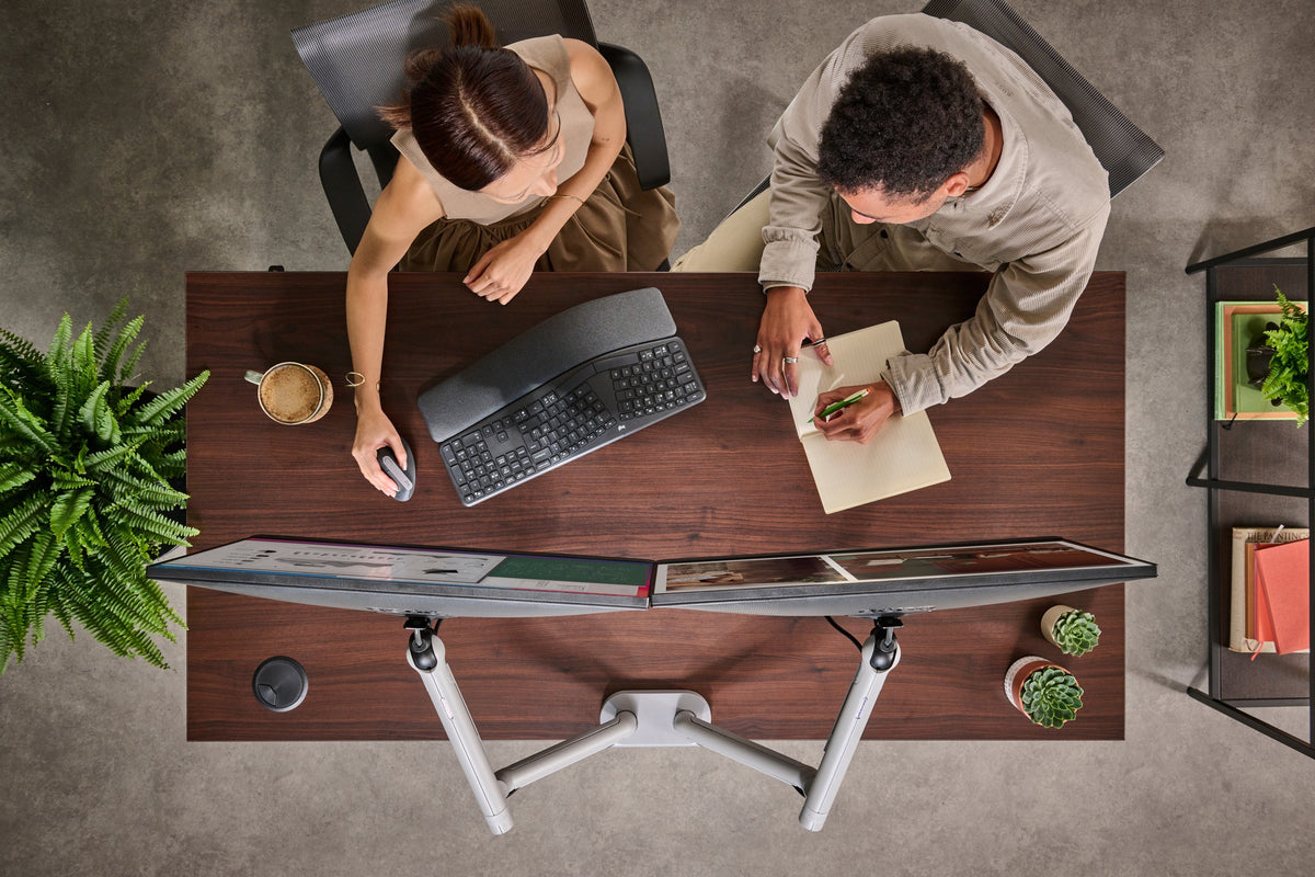 Overhead view of a CBS Flo Dual in silver holding two curved screens on a timber desk - Chair Dinkum Australia - Chair Dinkum