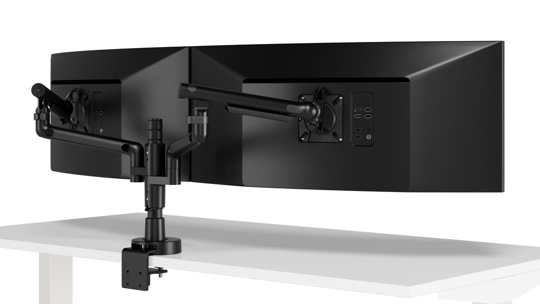 Two Colebrook Bosson Saunders Flo Modular arms in black carrying two curved screens on a shared post, three-quarter view, studio (Colebrook Bosson Saunders photograph)