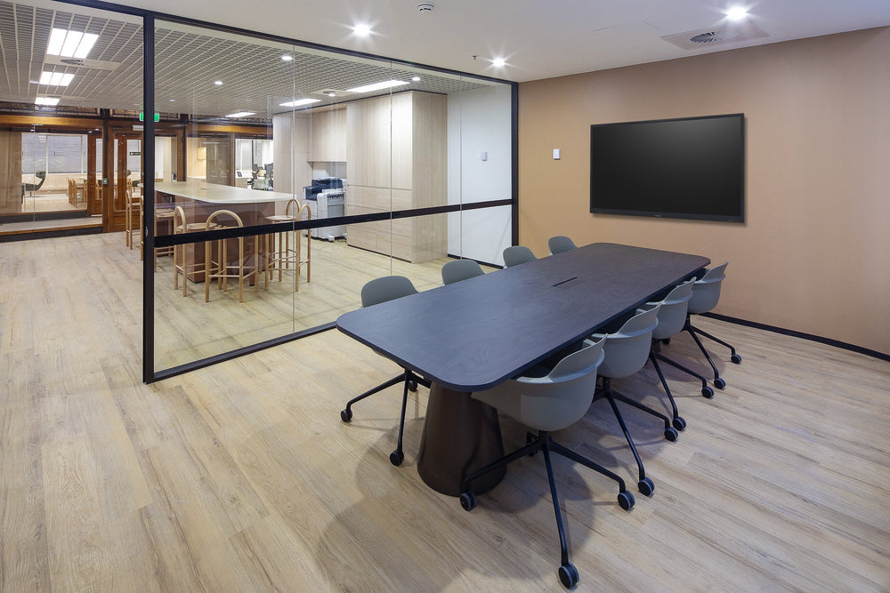Meeting room with a dark veneer table and grey shell chairs on castors