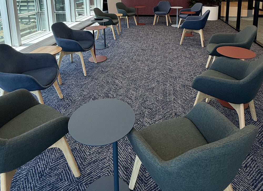 Lounge setting with navy and green tub armchairs and small round side tables