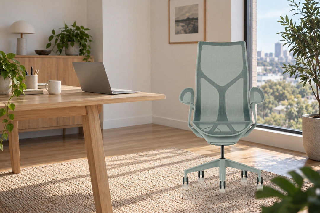 Herman Miller Cosm high back chair in Glacier with Leaf Arms on a rug beside a timber desk in a sunlit apartment office - Chair Dinkum Australia