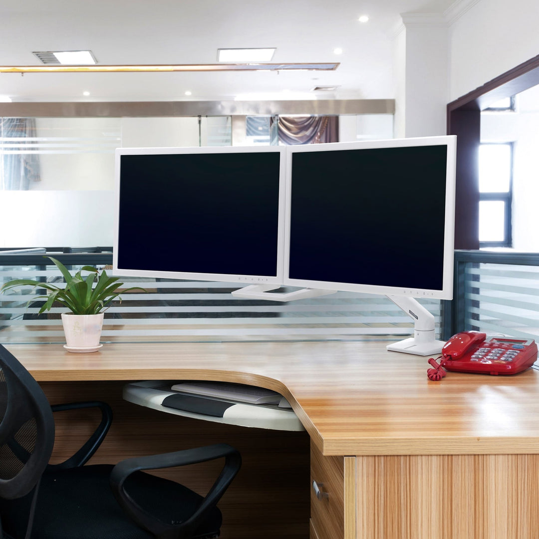 Corner office workstation with two white screens on a white Ergotron HX Dual Monitor Arm