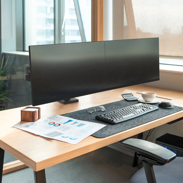 Office desk by a window with two screens side by side on a matte black Ergotron LX Pro dual arm