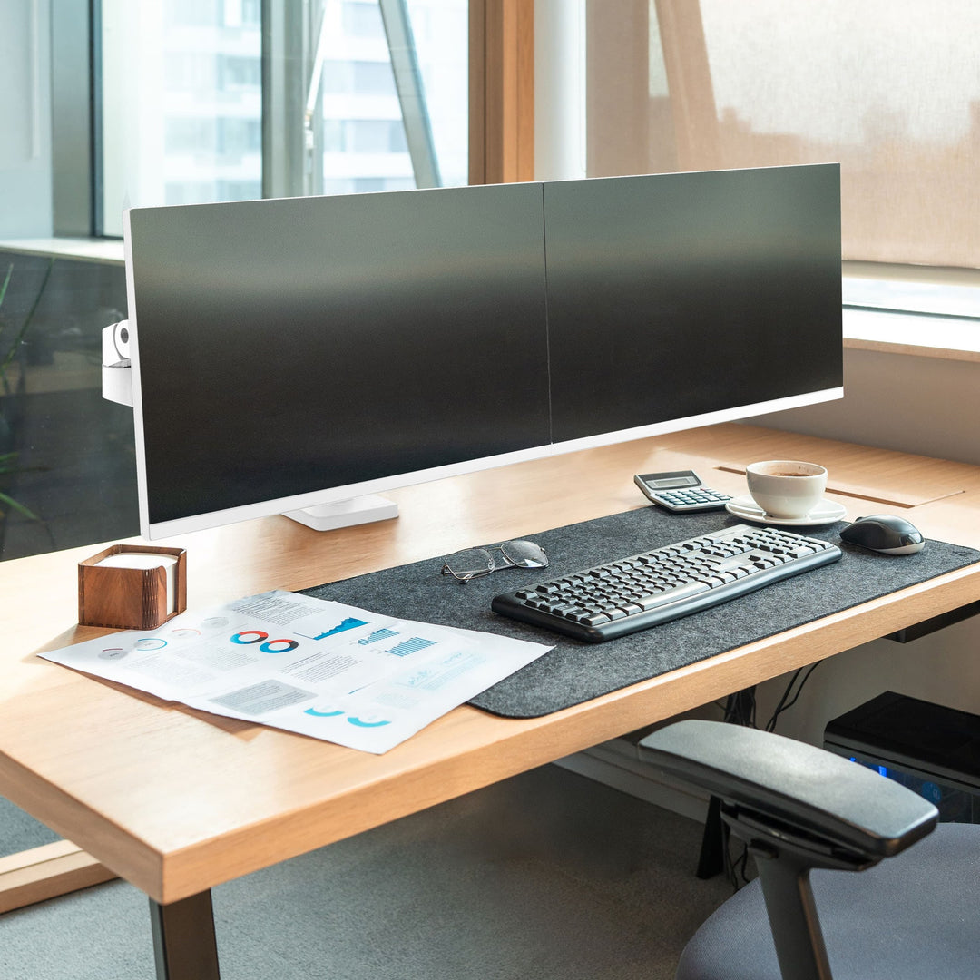 Office desk by a window with two screens side by side on a white Ergotron LX Pro dual arm