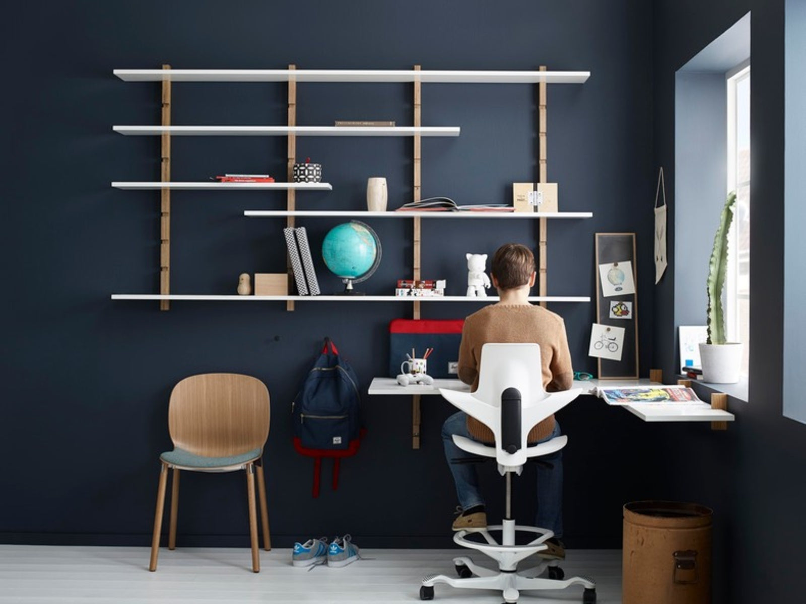 Person working at a conventional fixed-height desk on a HÅG Capisco Puls 8010 with the 200 mm gas lift