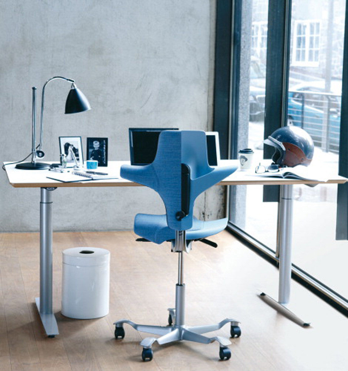 HÅG Capisco Puls 8010 raised to perching height at a standing desk, seat near the top of the 265 mm gas lift range
