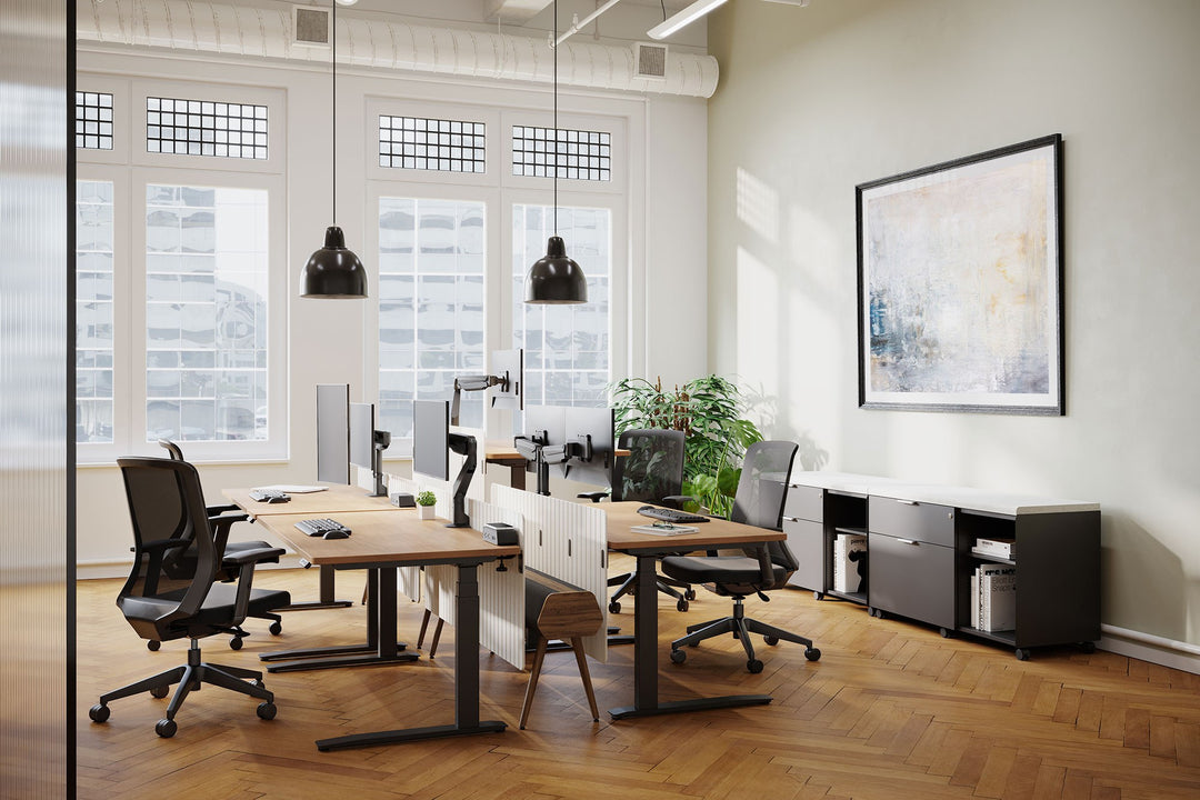 Office with rows of height-adjustable desks fitted with HAT Collective E2 monitor arms