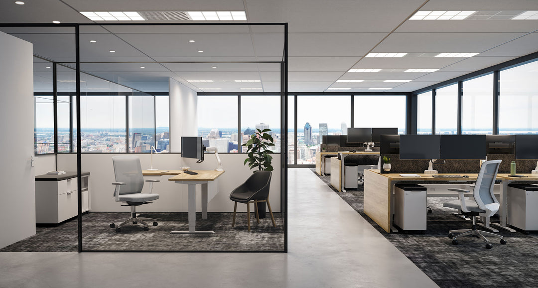 Open office with white HAT Collective E5 dual crossbar monitor arms on height-adjustable desks