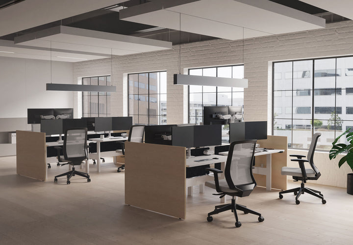 Open-plan benching with black HAT Collective E5 monitor arms behind screen panels