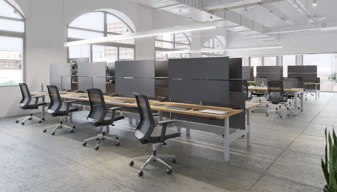 Open-plan benching with HAT Collective E5 one-over-one poles in silver holding stacked screens