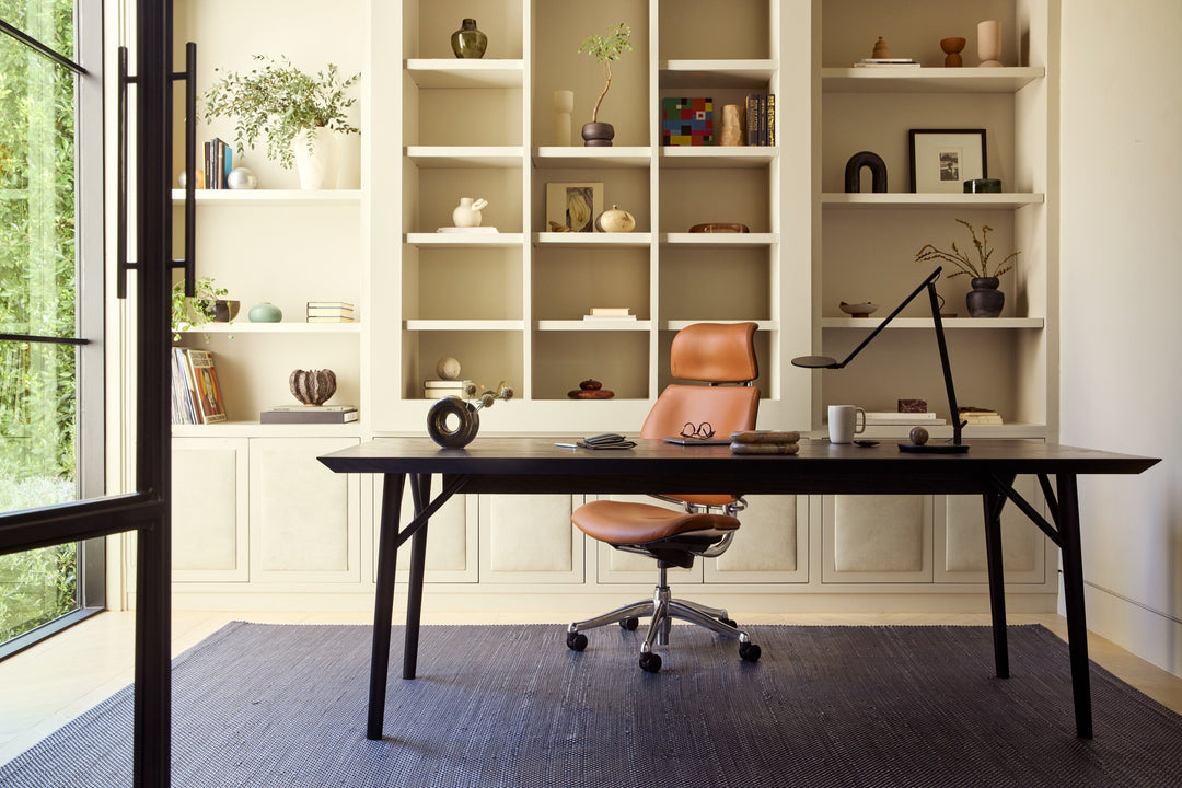 Humanscale Freedom Headrest chair in saddle leather at a timber executive desk in front of built-in bookshelves - Chair Dinkum Australia