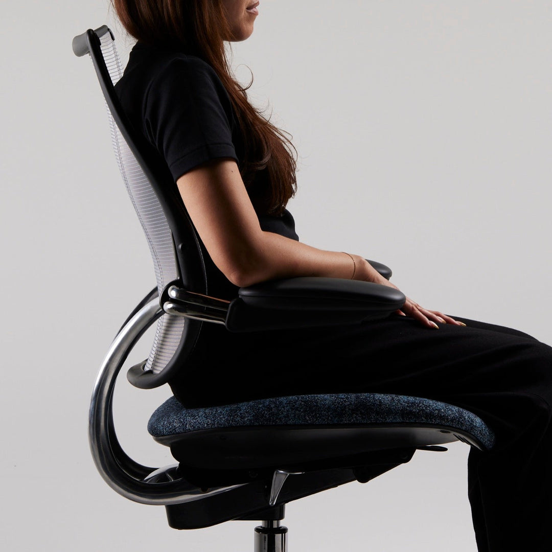Woman seated in side profile in a Humanscale Liberty task chair showing the recline and seat underside - Chair Dinkum Australia