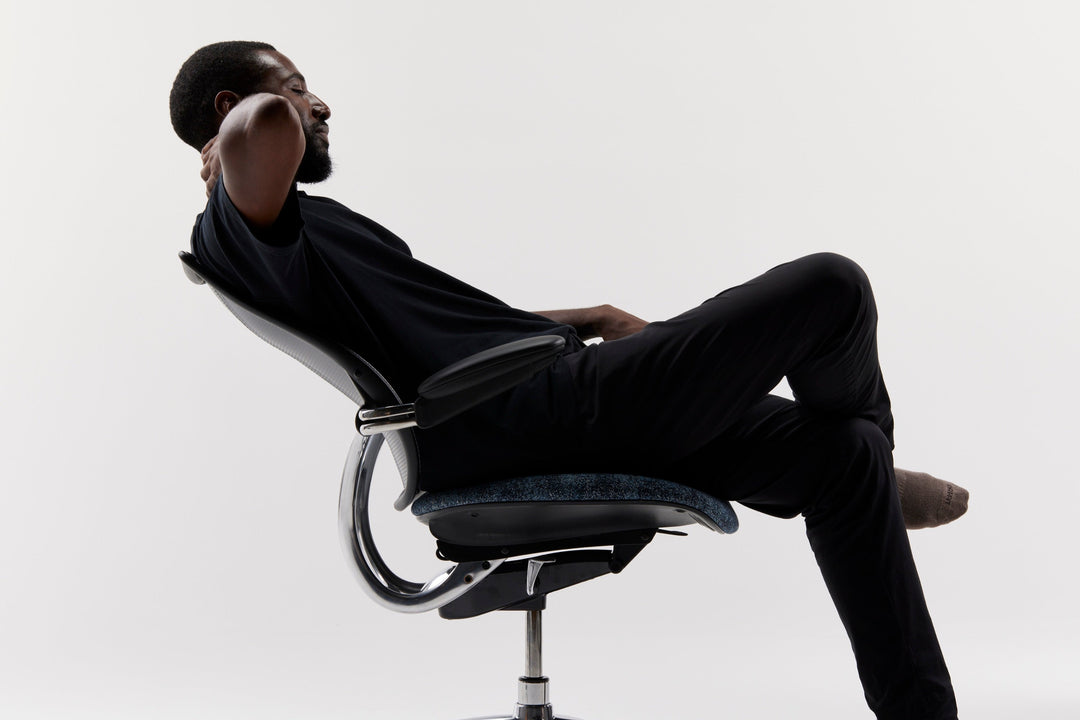 Man reclining in a polished-frame Humanscale Liberty task chair, side three-quarter view - Chair Dinkum Australia