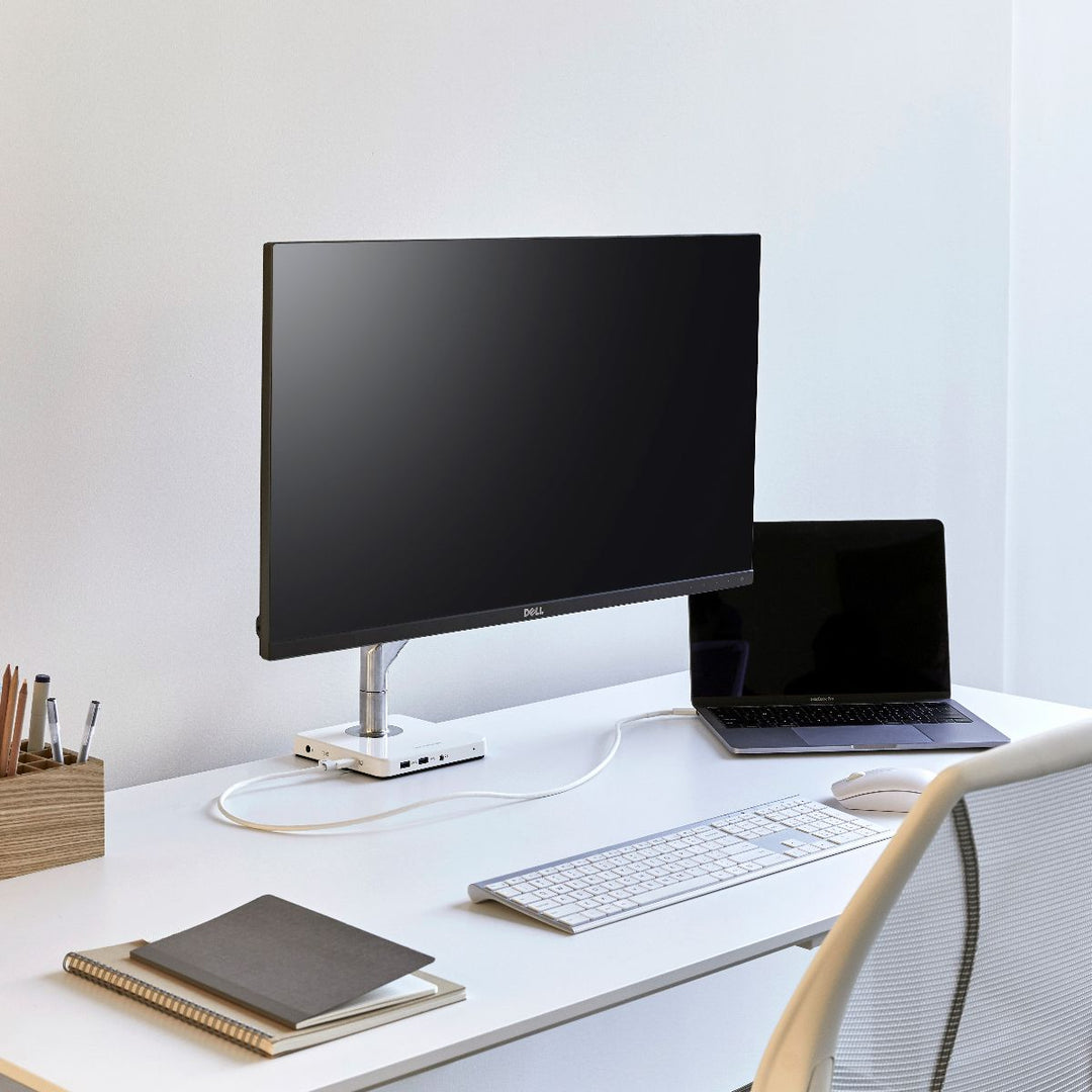 Humanscale M2.1 monitor arm on a white desk with a laptop and keyboard - Humanscale photograph