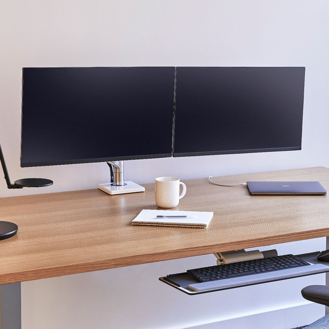 Humanscale M8.1 monitor arms carrying two screens at an office desk (Humanscale photograph)