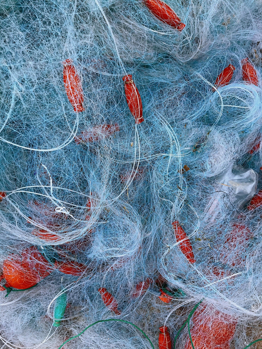 Tangle of recovered blue fishing nets with red floats