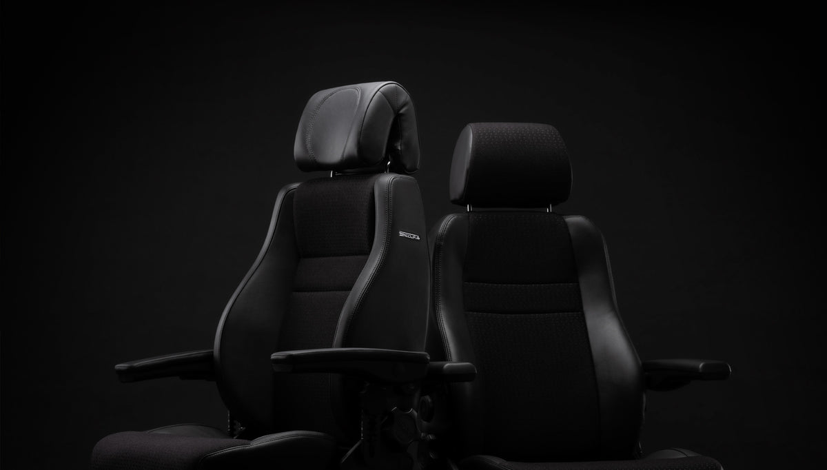 Two black RH Secur24 chairs side by side against a dark studio background, headrests fitted - Chair Dinkum Australia
