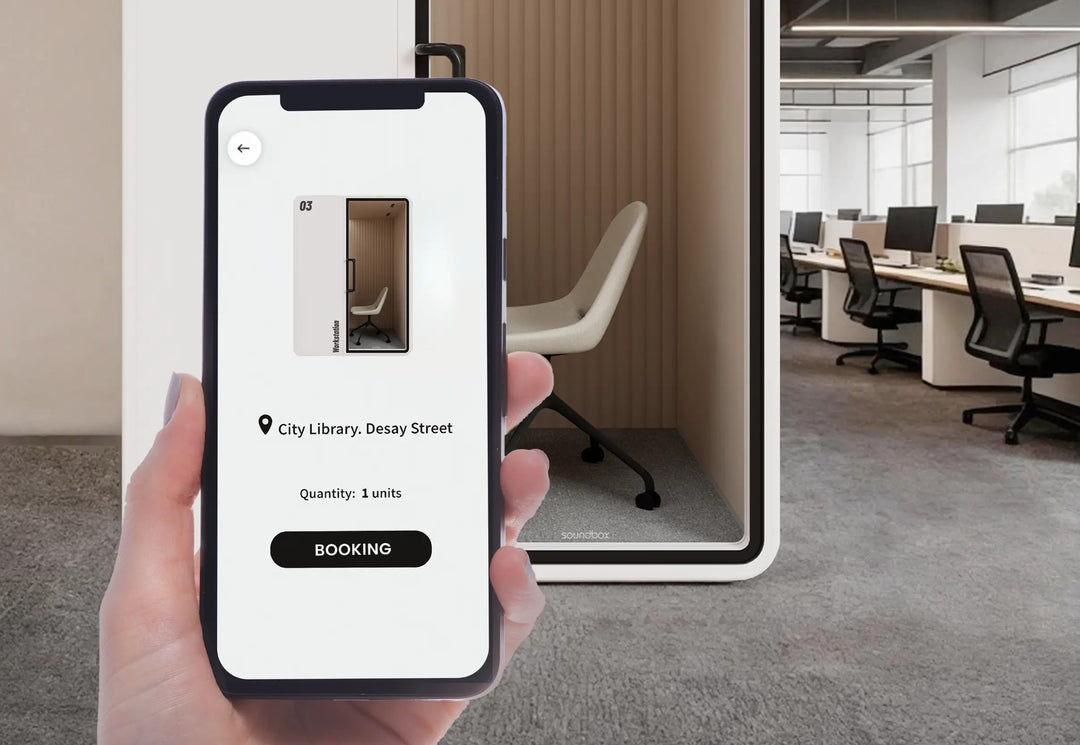 Phone showing the SoundBox app booking screen in front of a VRT M work booth - Chair Dinkum Australia