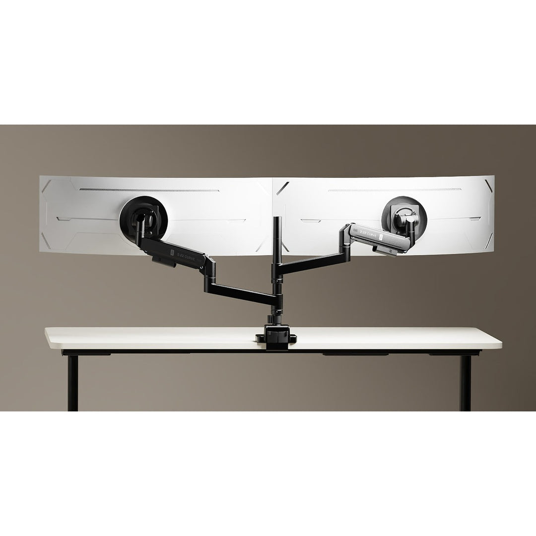 Two Thinking Works 2:22 Curve monitor arms in black on a shared desk pole, each holding a curved screen side by side above a white height-adjustable desk