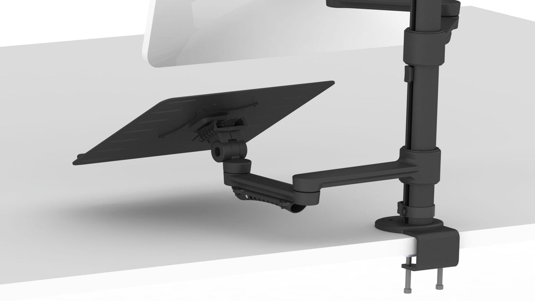 Black Thinking Works C.ME monitor arm clamped to a white desk, its lower arm holding a flat laptop tray, with a second arm and screen above.