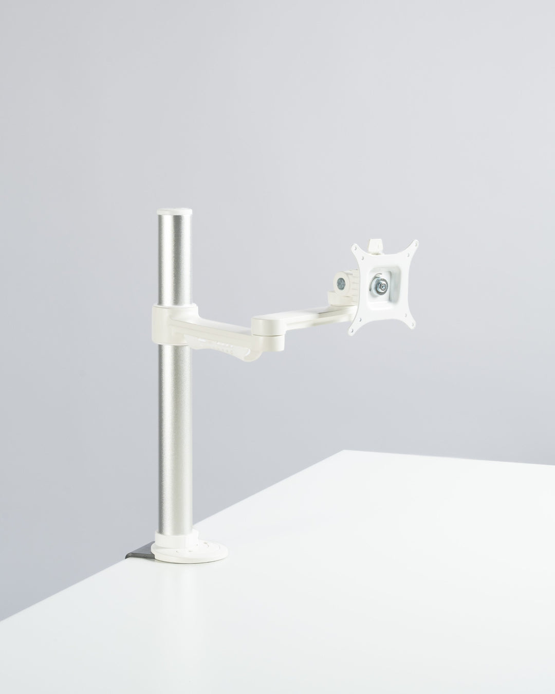 Thinking Works C.ME single monitor arm in matte white on a silver post, studio (Thinking Works photograph)