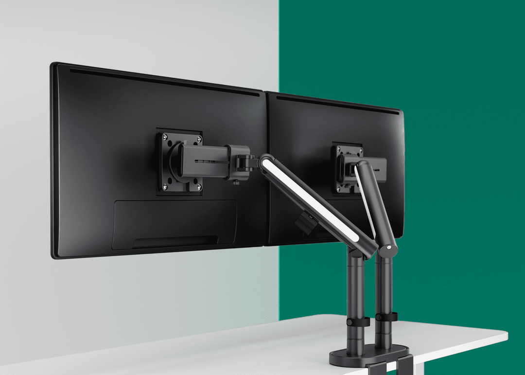Thinking Works Glider double monitor arm with two screens against a green wall