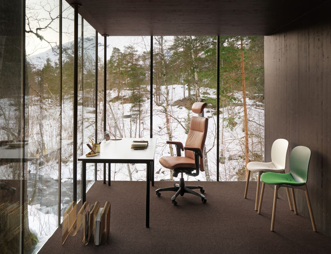 HÅG Tribute at a desk in a glass cabin with RBM Noor chairs, snow outside - Flokk photograph