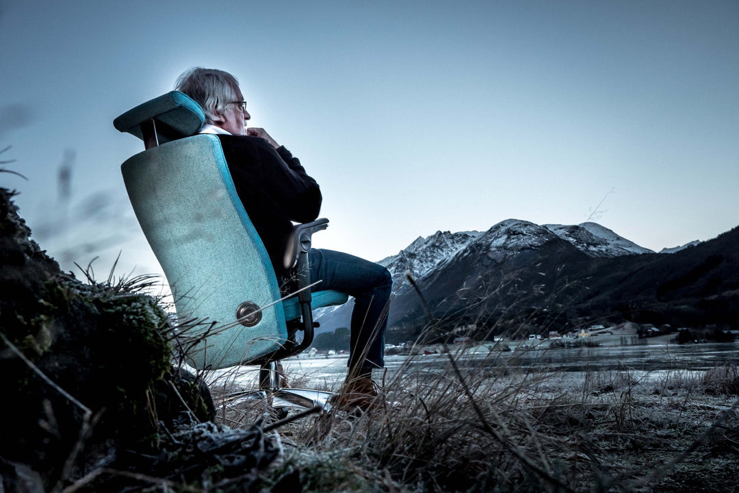Svein Asbjørnsen designer of HÅG Tribute sitting in executive chair overlooking Norwegian mountains - Chair Dinkum Australia